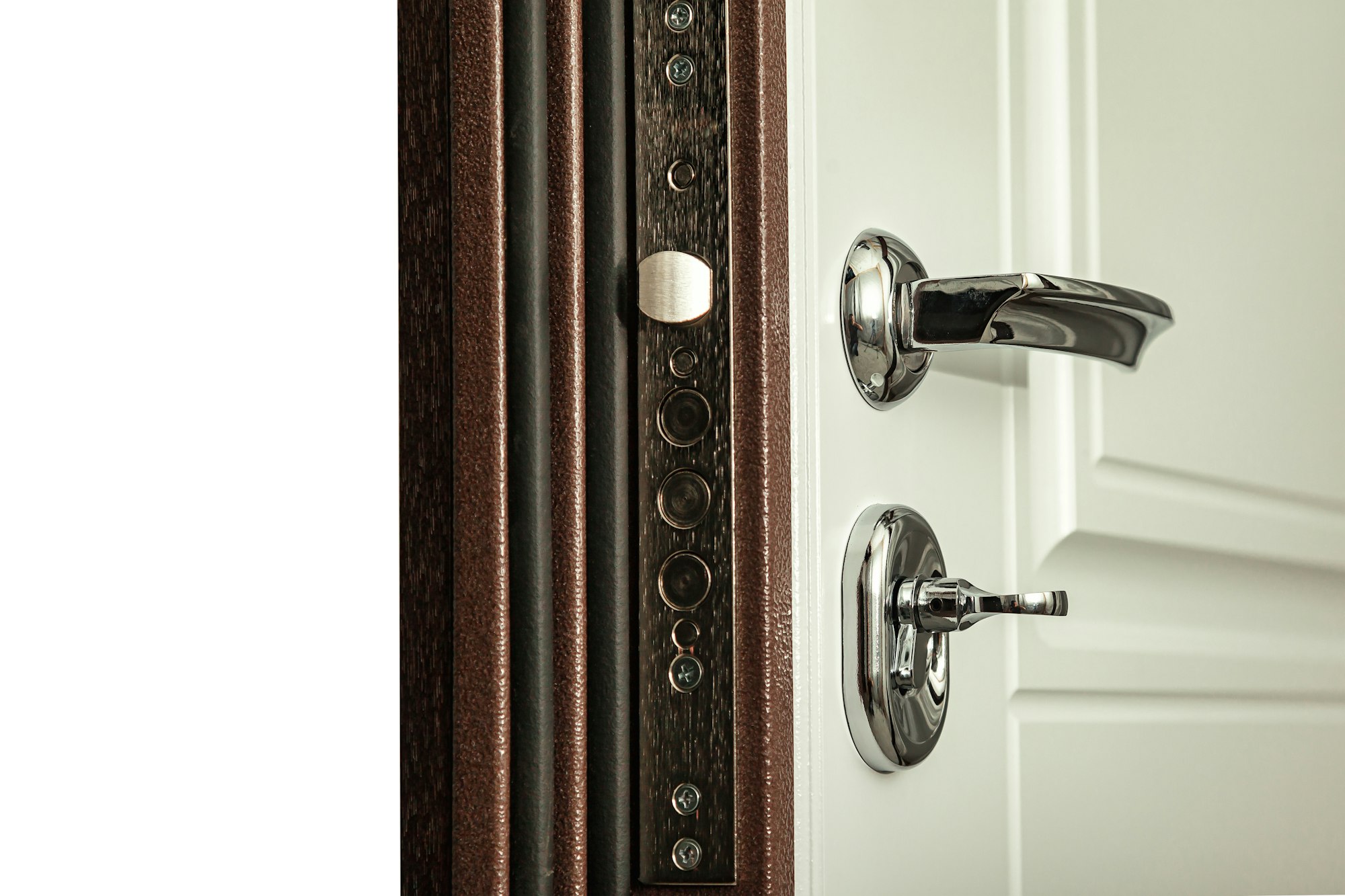 Closeup of modern steel armored door with chrome metal handle and locks